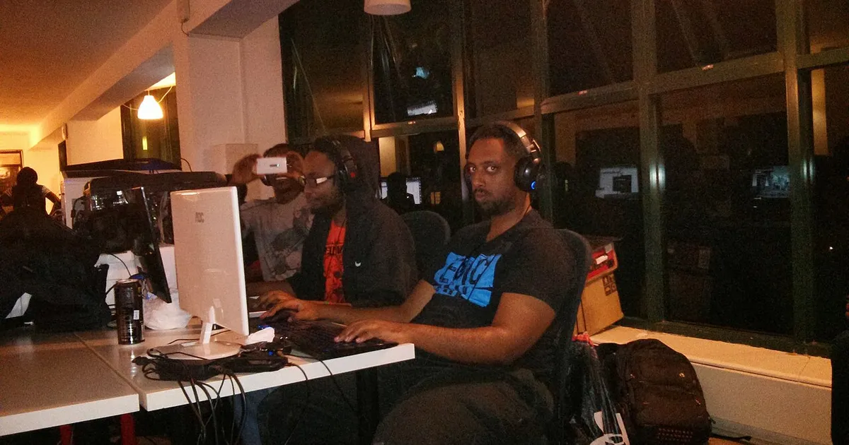 Gamers wearing headsets playing on PCs at a LAN party